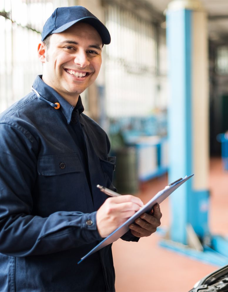 Happy technician ticking off a service sheet - Car Servicing Horsham